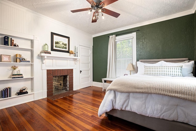 bedroom with dark hardwood / wood-style flooring, a brick fireplace, ceiling fan, and a textured ceiling