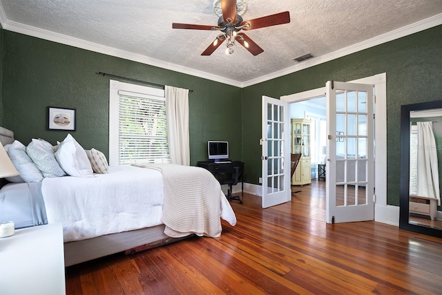 bedroom with ceiling fan, a textured ceiling, dark hardwood / wood-style floors, ornamental molding, and french doors