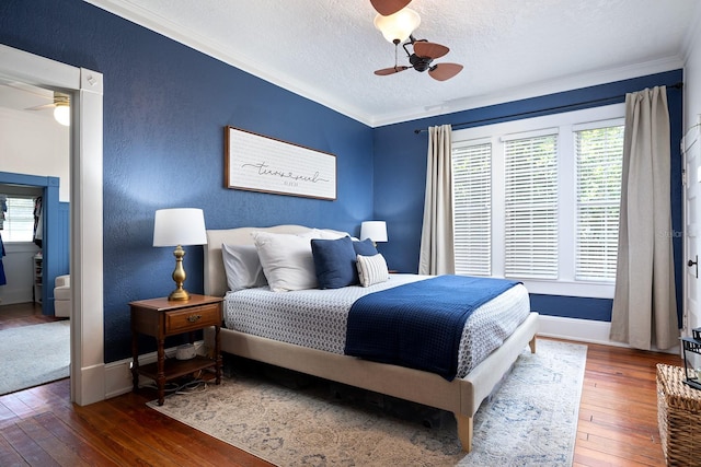 bedroom featuring crown molding, dark wood-type flooring, ceiling fan, and multiple windows