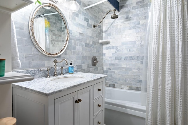 bathroom featuring vanity with extensive cabinet space, shower / bath combination with curtain, and tile walls