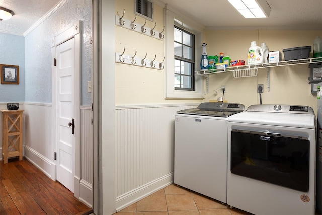 laundry room featuring separate washer and dryer, crown molding, light tile floors, and hookup for an electric dryer