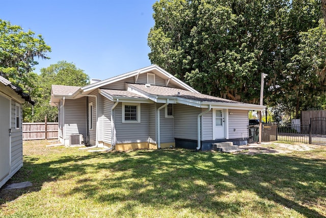 back of property featuring a yard and central air condition unit