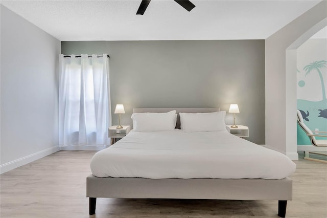 bedroom with wood-type flooring, ceiling fan, and multiple windows