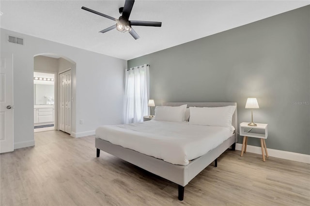 bedroom with ceiling fan, ensuite bathroom, and hardwood / wood-style flooring