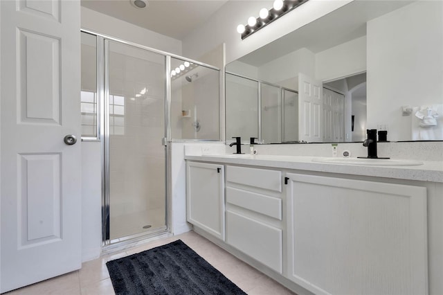 bathroom with a shower with door, tile flooring, and double sink vanity