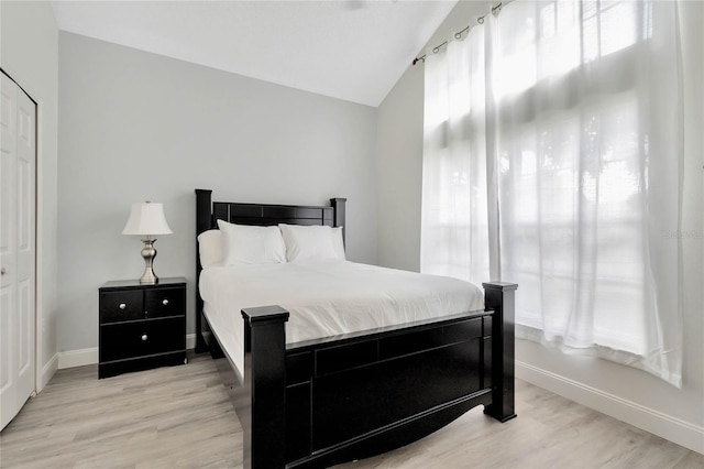 bedroom featuring light wood-type flooring and lofted ceiling