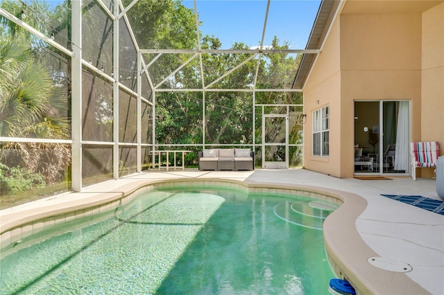 view of swimming pool featuring glass enclosure and a patio