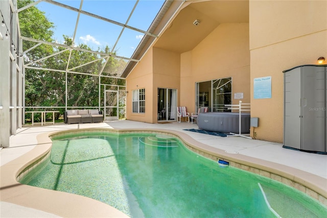 view of swimming pool featuring a patio area, an outdoor hangout area, and glass enclosure