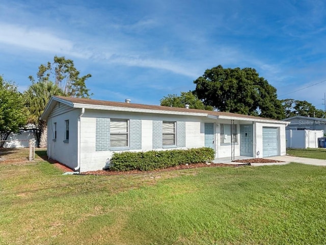 ranch-style house featuring a garage and a front lawn