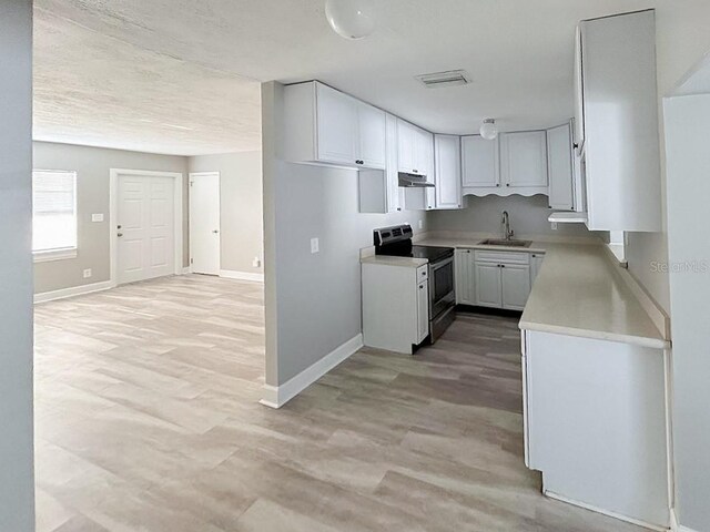 kitchen featuring sink, electric stove, white cabinetry, and hardwood / wood-style flooring