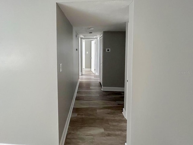 corridor with dark hardwood / wood-style flooring