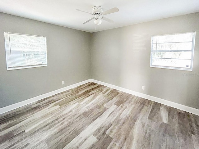 unfurnished room with ceiling fan, a healthy amount of sunlight, and hardwood / wood-style floors