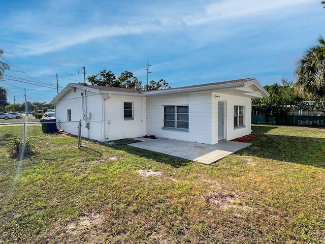 rear view of property featuring a patio and a yard