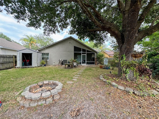 view of yard with a sunroom, a storage shed, and an outdoor fire pit