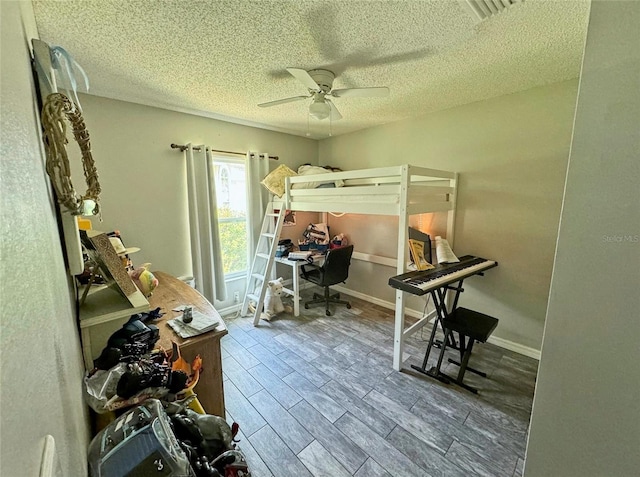 bedroom featuring wood-type flooring, ceiling fan, and a textured ceiling