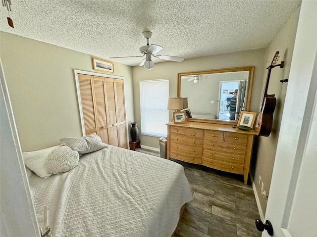 bedroom with dark wood-type flooring, a textured ceiling, ceiling fan, and a closet