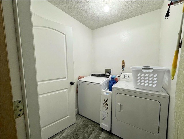 clothes washing area featuring dark wood-type flooring, a textured ceiling, and independent washer and dryer