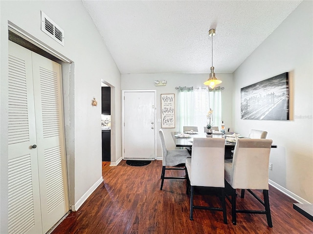 dining area featuring a textured ceiling and dark hardwood / wood-style flooring