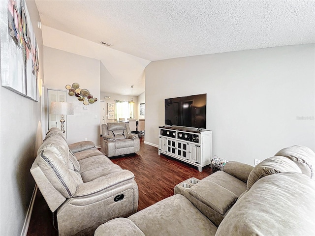 living room featuring dark hardwood / wood-style floors, vaulted ceiling, and a textured ceiling