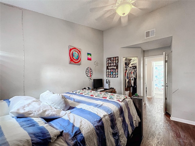 bedroom featuring a closet, ceiling fan, dark hardwood / wood-style flooring, and a textured ceiling