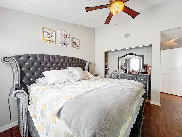 bedroom with dark hardwood / wood-style flooring, ceiling fan, and a textured ceiling