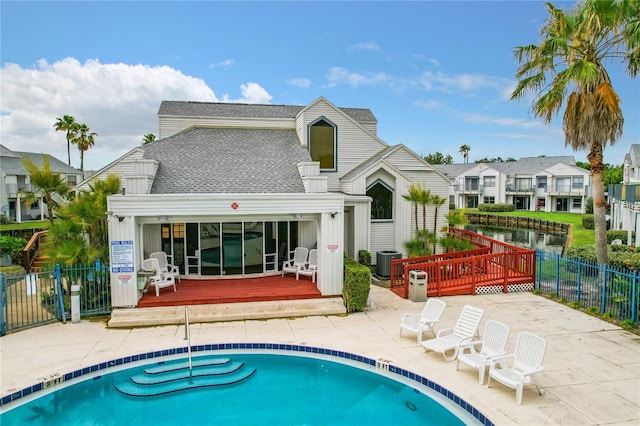 rear view of house with a swimming pool side deck and central air condition unit