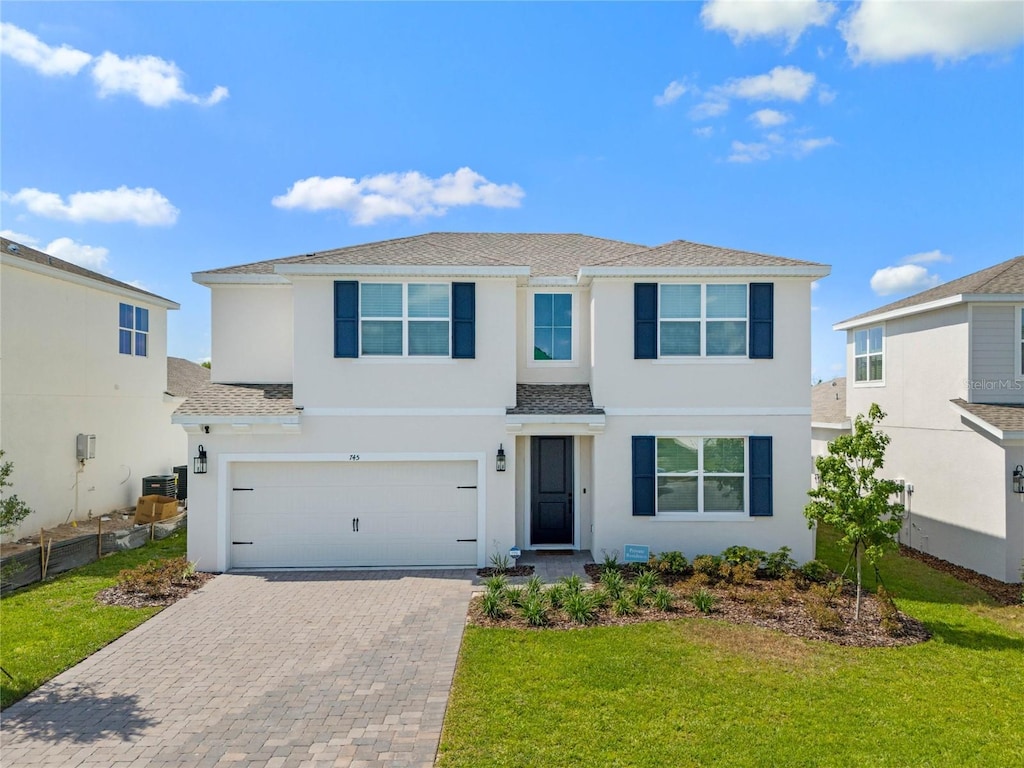 view of front of property with a garage and a front lawn