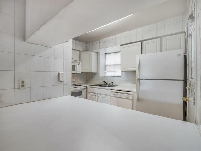 kitchen featuring white cabinetry, sink, tasteful backsplash, and white appliances