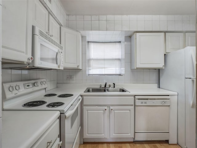 kitchen with sink, light wood-type flooring, white appliances, tasteful backsplash, and white cabinets