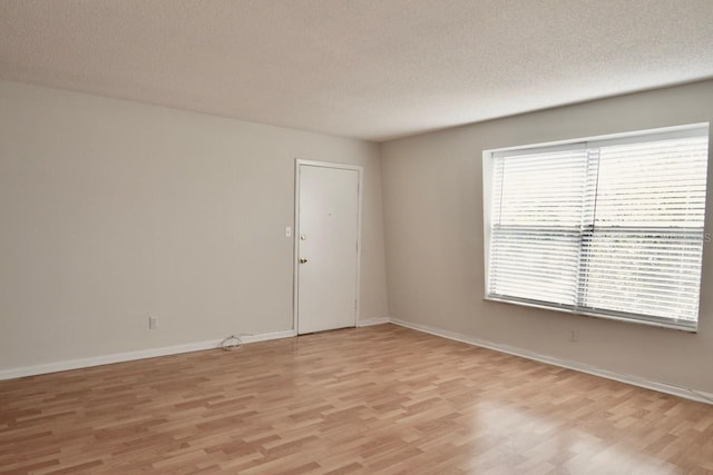 empty room featuring light hardwood / wood-style floors and a textured ceiling