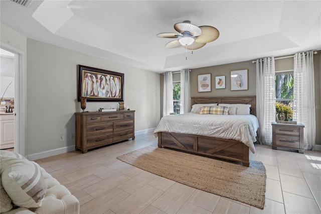 bedroom with ceiling fan and a raised ceiling