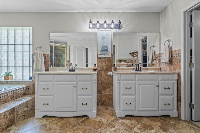 bathroom featuring dual bowl vanity, tiled tub, and tile flooring