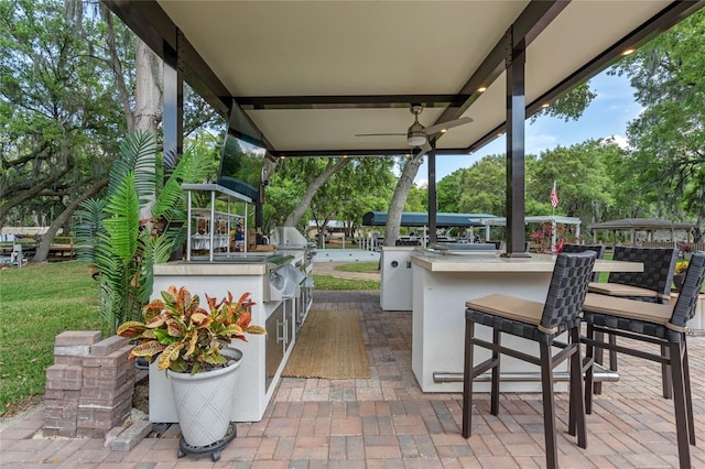 view of terrace featuring a grill, a bar, and an outdoor kitchen