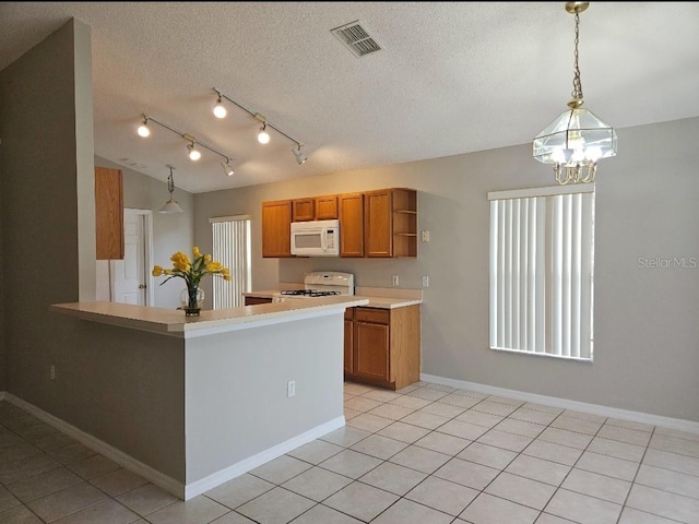 kitchen with lofted ceiling, hanging light fixtures, stove, kitchen peninsula, and a textured ceiling