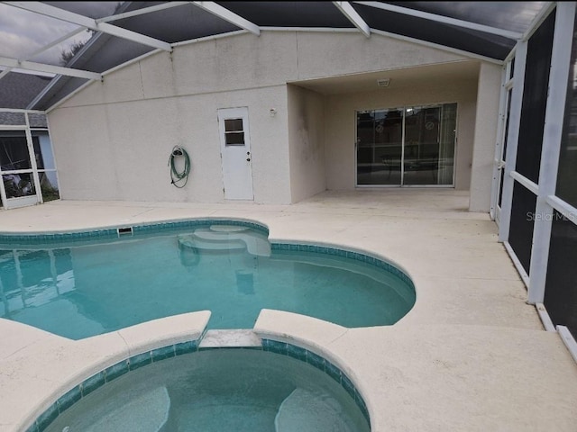 view of pool with an in ground hot tub, a lanai, and a patio area