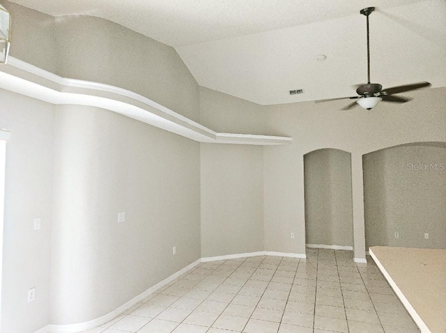 tiled empty room with ceiling fan and lofted ceiling