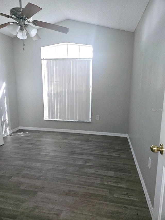 spare room with lofted ceiling, a textured ceiling, dark hardwood / wood-style floors, and ceiling fan