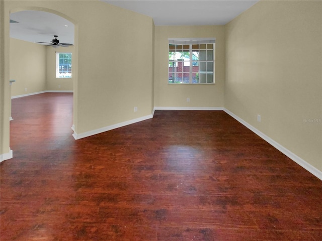 empty room featuring ceiling fan, a healthy amount of sunlight, and hardwood / wood-style flooring