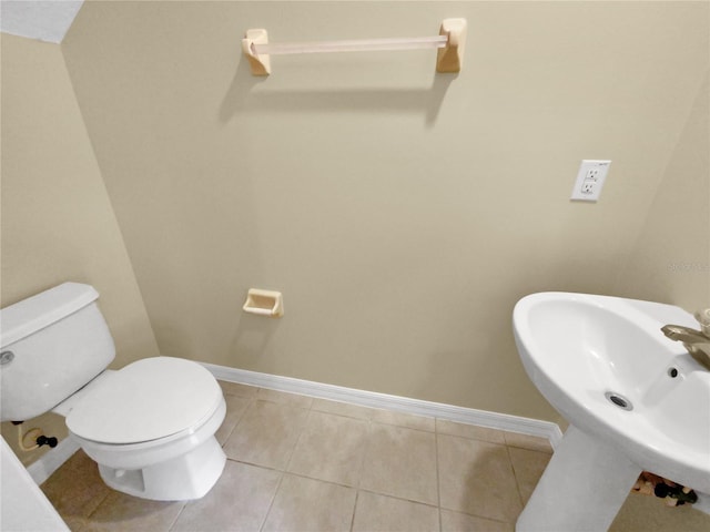 bathroom featuring sink, tile floors, and toilet