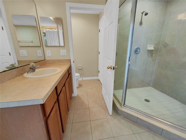 bathroom with a shower with shower door, vanity, toilet, and tile flooring