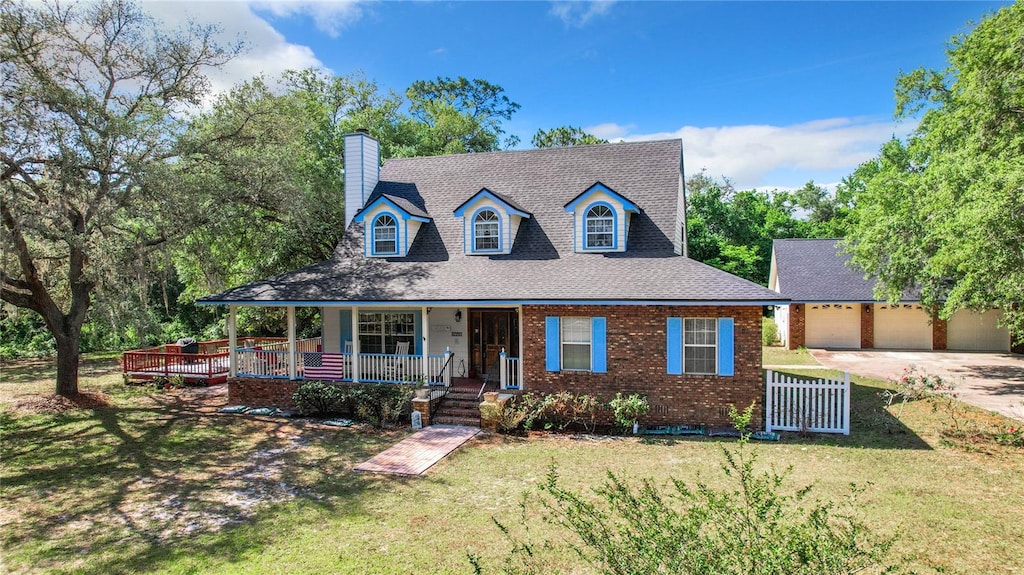 view of front of property featuring a front yard, a porch, and a garage