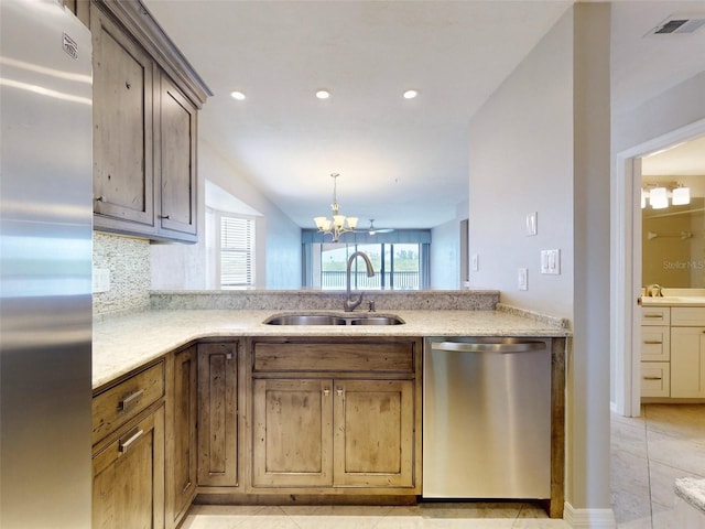 kitchen featuring lofted ceiling, sink, decorative backsplash, stainless steel appliances, and a chandelier