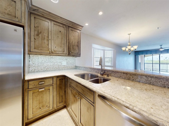 kitchen with appliances with stainless steel finishes, backsplash, a healthy amount of sunlight, and sink