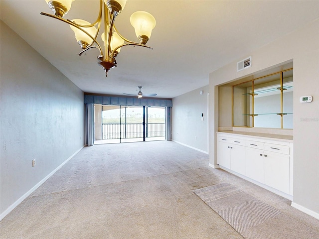 unfurnished living room featuring light carpet and ceiling fan with notable chandelier