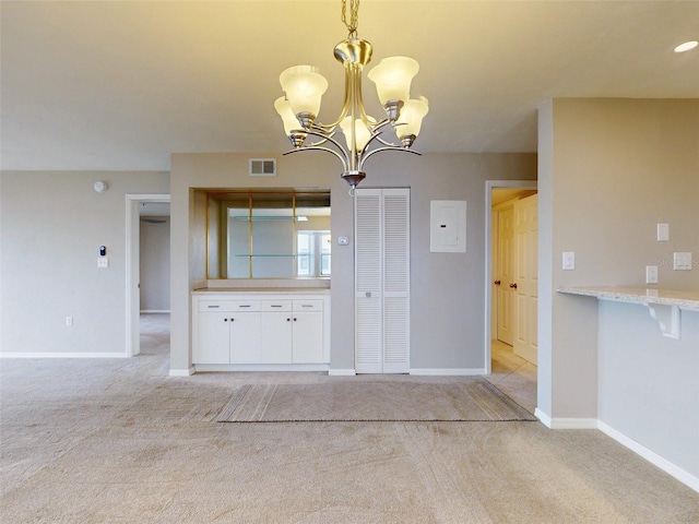 unfurnished dining area with light colored carpet, electric panel, and a chandelier