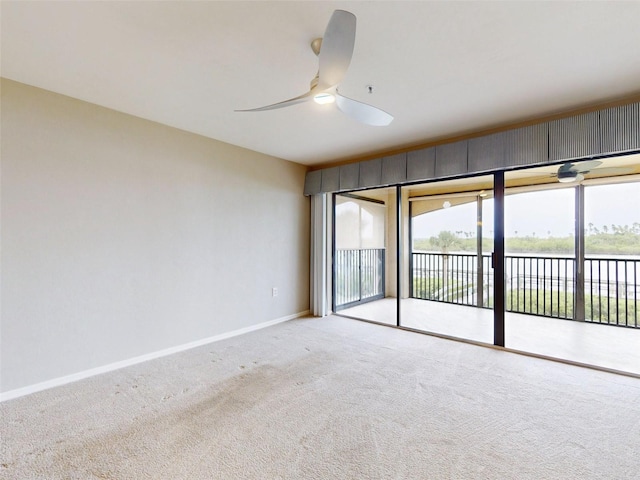 spare room with ceiling fan, a water view, and light carpet