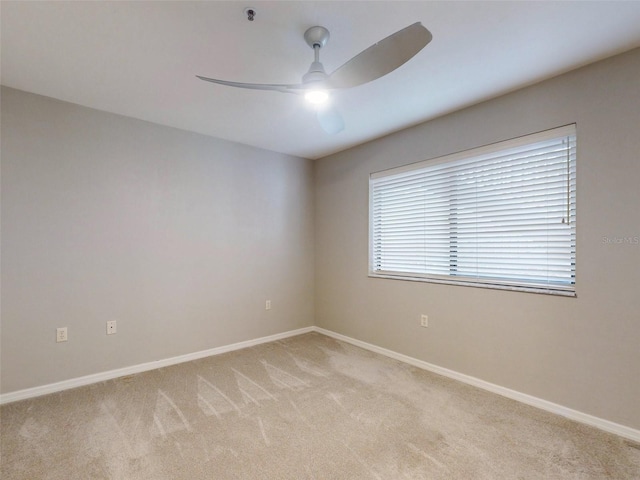 carpeted spare room featuring ceiling fan