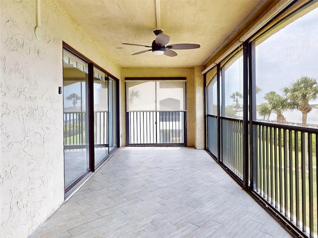 unfurnished sunroom featuring ceiling fan