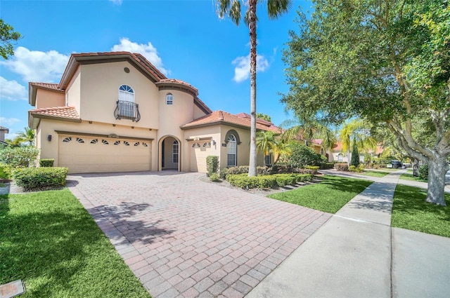 mediterranean / spanish-style home with a garage and a front lawn