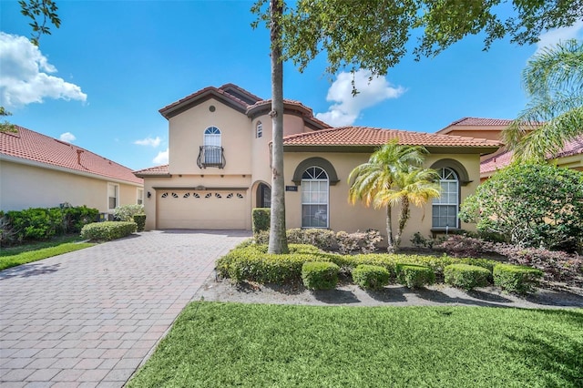 mediterranean / spanish-style home with a garage and a front yard